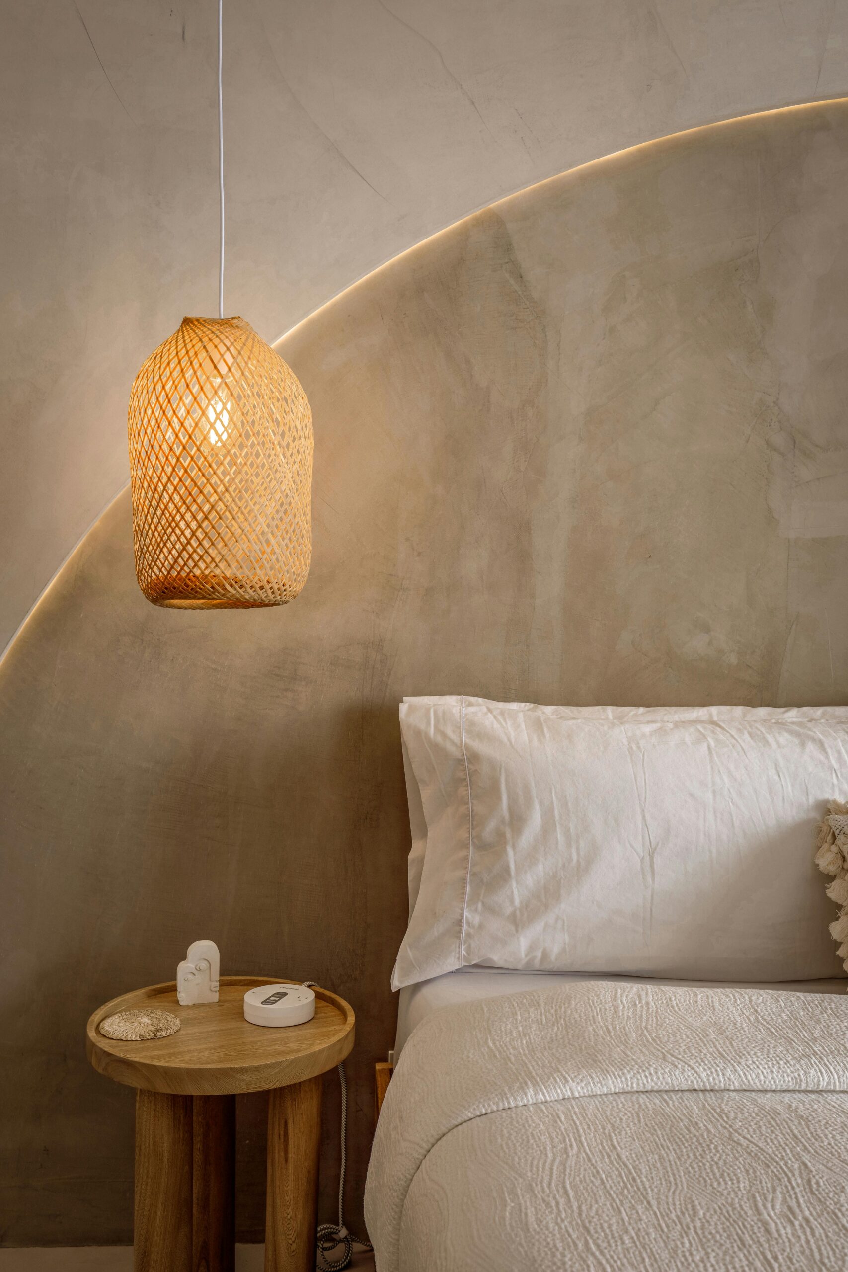 Explore Elegant minimalist bedroom featuring woven lamp and soft white bedding.
